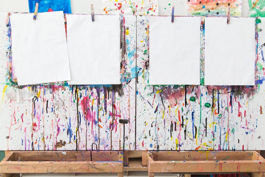 feuille blanche accroché sur une corde à linge avec un mur peint en multicolore